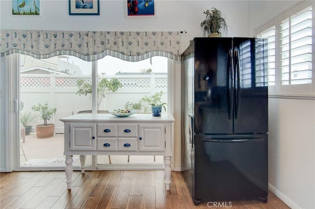 17072 5th St Unit A, Sunset Beach, CA 90742 - kitchen featuring freestanding refrigerator, wood finished floors, and white cabinetry