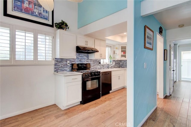 17072 5th St Unit A, Sunset Beach, CA 90742 - kitchen featuring light wood finished floors, decorative backsplash, light countertops, black appliances, and white cabinets