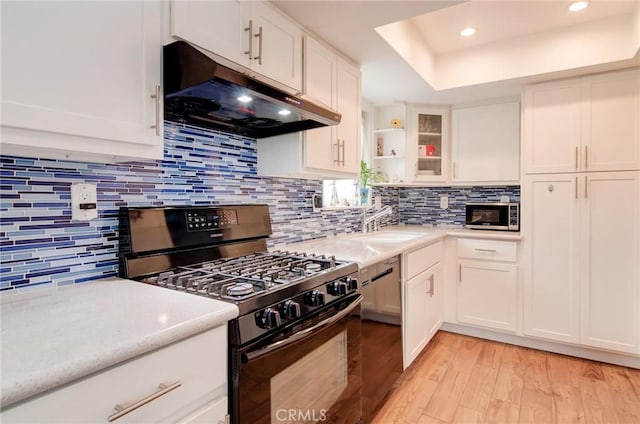 17072 5th St Unit A, Sunset Beach, CA 90742 - kitchen with appliances with stainless steel finishes, under cabinet range hood, light countertops, light wood finished floors, and recessed lighting