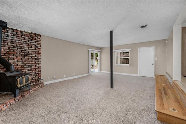 404 W Robinson Ave, Fresno, CA 93705 - unfurnished living room with a wood stove, a textured ceiling, and carpet floors