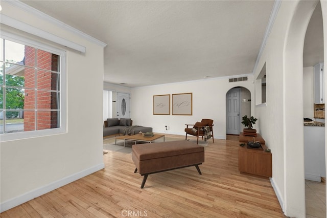 404 W Robinson Ave, Fresno, CA 93705 - living room with arched walkways, light wood-style flooring, and crown molding
