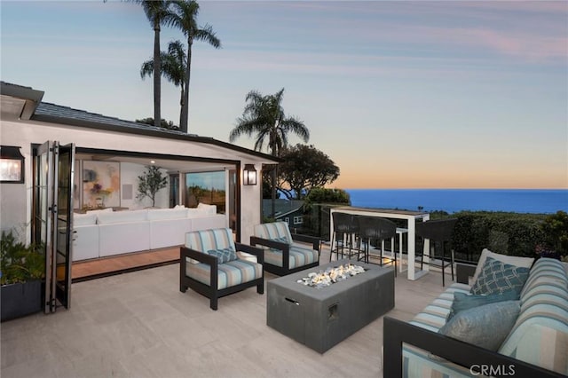 2570 Queda Way, Laguna Beach, CA 92651 - patio terrace at dusk featuring an outdoor living space with a fire pit, a water view, and a patio area