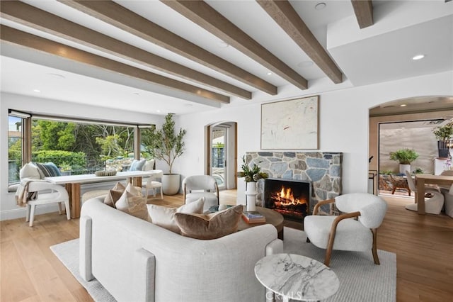 2570 Queda Way, Laguna Beach, CA 92651 - living area featuring arched walkways, a stone fireplace, beamed ceiling, light wood finished floors, and recessed lighting