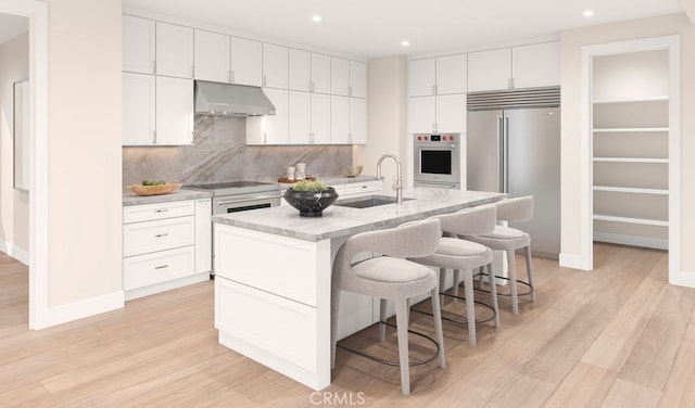 2064 E Pearl St, Encinitas, CA 92024 - kitchen featuring under cabinet range hood, white cabinetry, stainless steel built in fridge, a kitchen bar, and recessed lighting