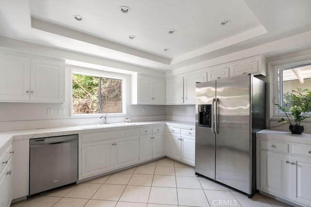 2443 Windward Ln, Newport Beach, CA 92660 - kitchen featuring stainless steel appliances, a tray ceiling, tile counters, white cabinets, and recessed lighting