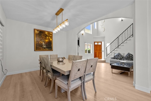 18340 Keswick St Unit 5, Reseda, CA 91335 - dining room featuring arched walkways, light wood-type flooring, and stairway