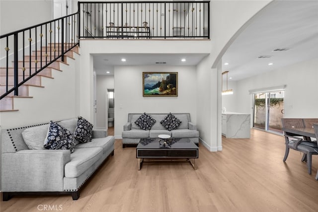 18340 Keswick St Unit 5, Reseda, CA 91335 - living area featuring wood finished floors, arched walkways, stairway, recessed lighting, and a towering ceiling