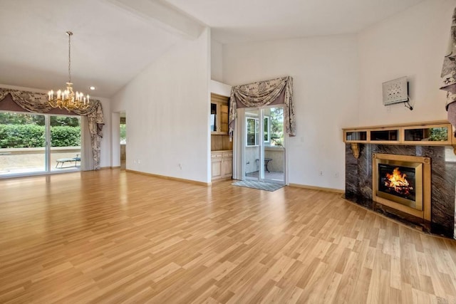 61 Via Larga Vis, Bonsall, CA 92003 - unfurnished living room featuring a high end fireplace, high vaulted ceiling, a chandelier, beamed ceiling, and wood finished floors