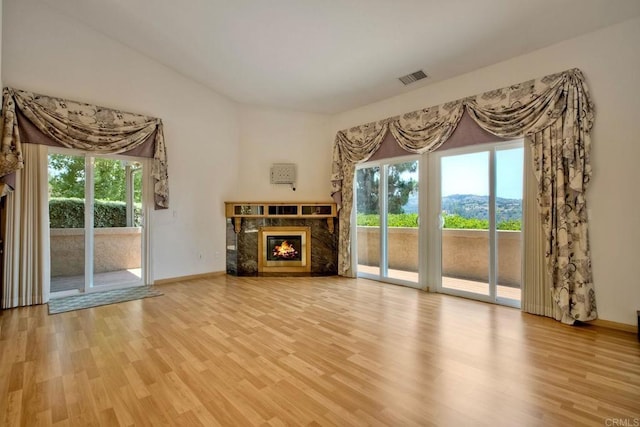 61 Via Larga Vis, Bonsall, CA 92003 - unfurnished living room with a high end fireplace, wood finished floors, and healthy amount of natural light