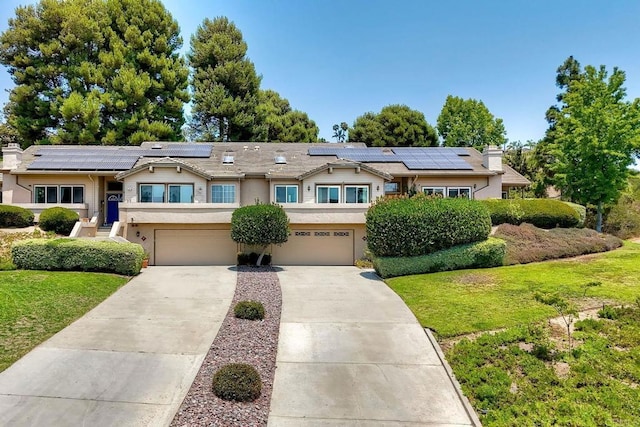 61 Via Larga Vis, Bonsall, CA 92003 - view of front of home featuring concrete driveway, a front yard, a garage, and roof mounted solar panels