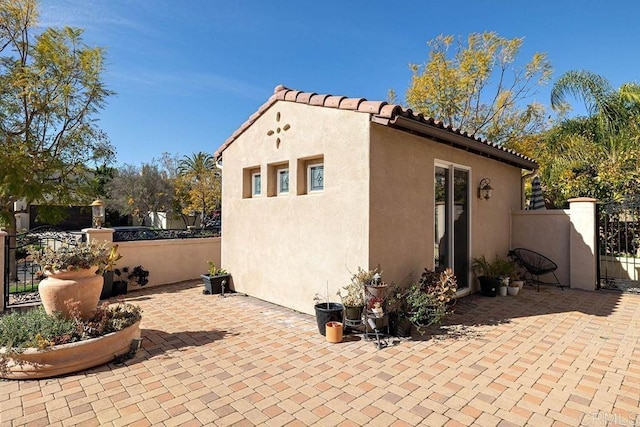 2856 Falling Waters Ct, Chula Vista, CA 91915 - view of side of home featuring a gate, stucco siding, a patio, and a tile roof