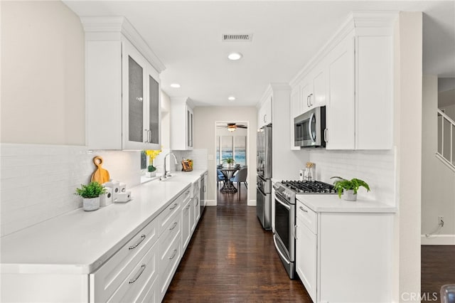 1336 Granada St, Upland, CA 91784 - kitchen with stainless steel appliances, recessed lighting, decorative backsplash, white cabinets, and glass insert cabinets