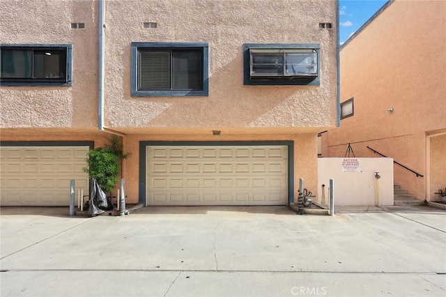 513 N Chandler Ave Unit E, Monterey Park, CA 91754 - view of front of property with stucco siding, a garage, and driveway