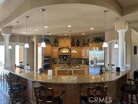 17134 Joshua Rd, Apple Valley, CA 92307 - kitchen featuring a kitchen bar, a spacious island, appliances with stainless steel finishes, tasteful backsplash, and light stone countertops