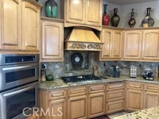 17134 Joshua Rd, Apple Valley, CA 92307 - kitchen featuring double oven, custom range hood, decorative backsplash, light brown cabinets, and light stone counters