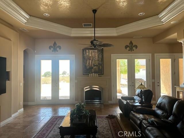 17134 Joshua Rd, Apple Valley, CA 92307 - living area featuring french doors, a raised ceiling, ornamental molding, arched walkways, and a fireplace