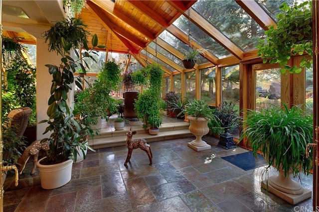 sunroom / solarium featuring vaulted ceiling with beams