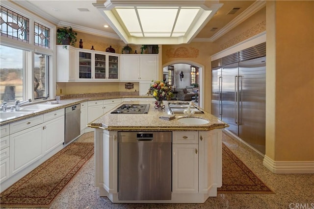 kitchen with appliances with stainless steel finishes, white cabinetry, and an island with sink