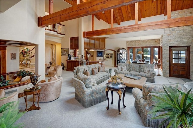 carpeted living room with wood ceiling, high vaulted ceiling, and beamed ceiling