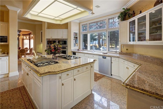 kitchen featuring white cabinets, plenty of natural light, black appliances, and ornamental molding