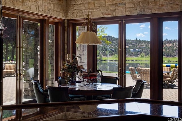 sunroom with plenty of natural light and a water view