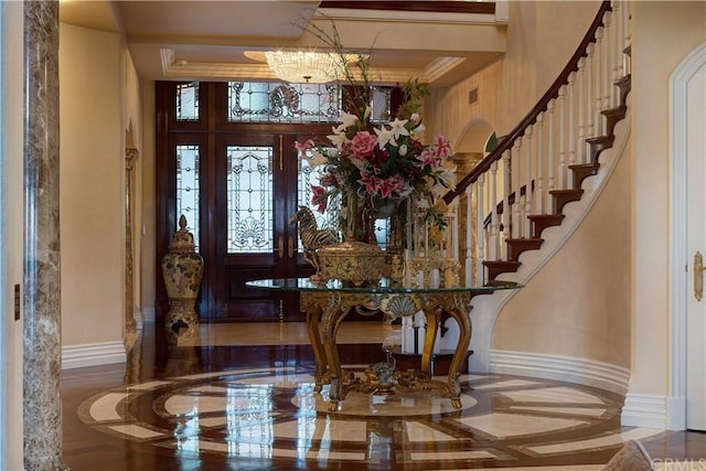 foyer featuring crown molding, an inviting chandelier, and wood-type flooring