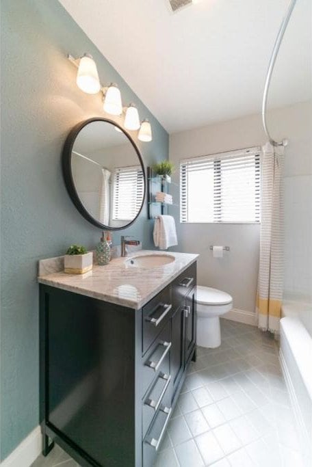 full bathroom featuring shower / bath combination with curtain, vanity, toilet, and tile patterned floors