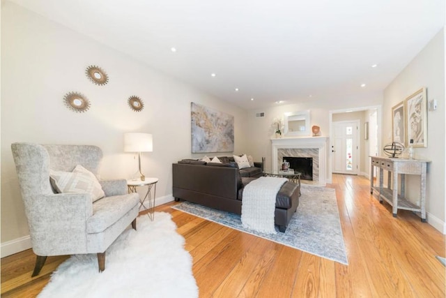 living room featuring a premium fireplace and light hardwood / wood-style floors