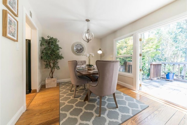 dining space featuring light hardwood / wood-style flooring and a chandelier