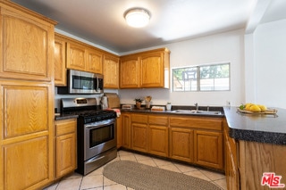 kitchen featuring sink, appliances with stainless steel finishes, and light tile patterned floors