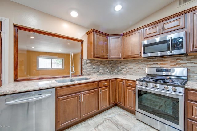 kitchen featuring appliances with stainless steel finishes, light tile patterned flooring, tasteful backsplash, sink, and light stone counters