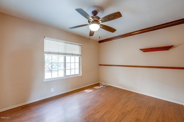 empty room featuring hardwood / wood-style floors, crown molding, and ceiling fan