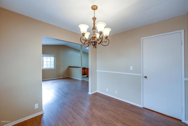 empty room featuring a notable chandelier and hardwood / wood-style floors