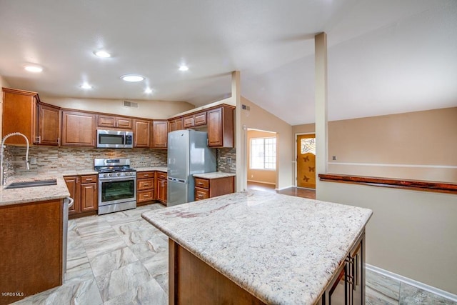 kitchen with lofted ceiling, stainless steel appliances, sink, tasteful backsplash, and light tile patterned flooring