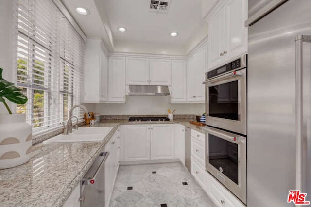 kitchen with sink, stainless steel appliances, light tile patterned floors, and a healthy amount of sunlight