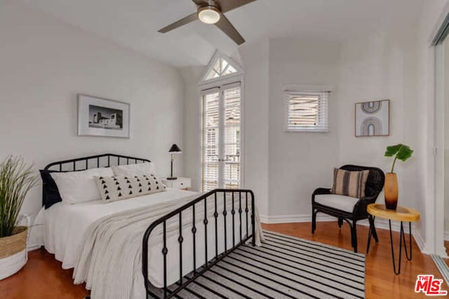 bedroom with ceiling fan, lofted ceiling, and hardwood / wood-style floors