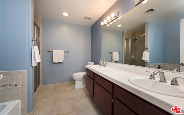 full bathroom featuring dual vanity, tile patterned floors, toilet, and separate shower and tub