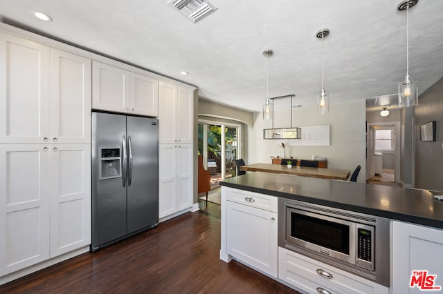 kitchen with white cabinets, decorative light fixtures, dark hardwood / wood-style flooring, and stainless steel appliances