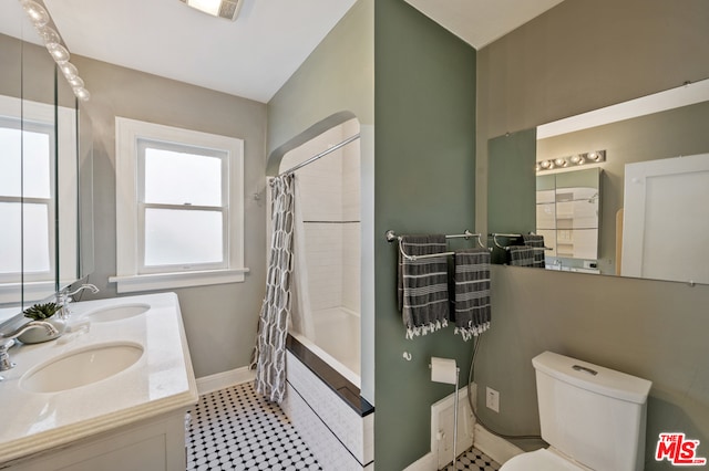 full bathroom with shower / bath combo with shower curtain, toilet, double vanity, and tile floors