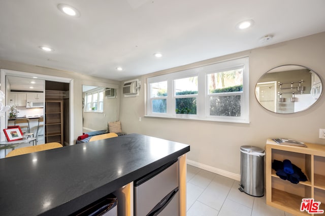 kitchen with a wall mounted air conditioner and light tile flooring