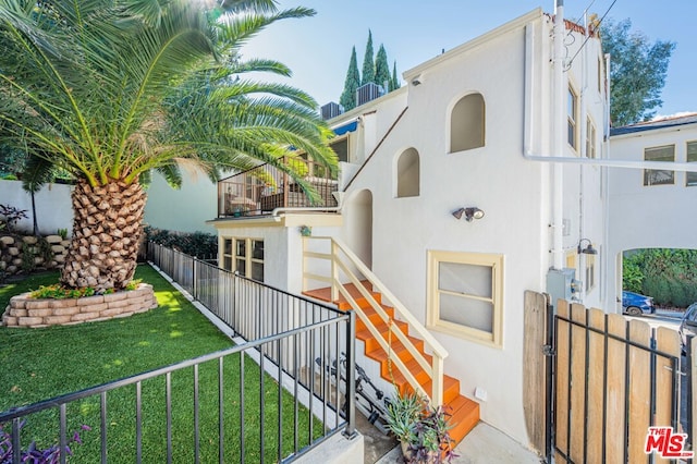 view of front of property featuring a balcony and a front yard