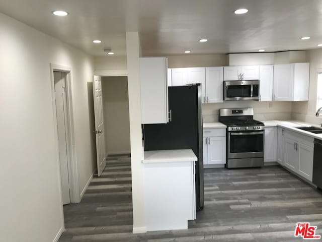 kitchen with black appliances, white cabinetry, sink, and dark hardwood / wood-style flooring