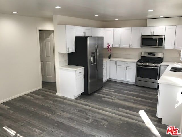 kitchen featuring white cabinets, appliances with stainless steel finishes, and dark hardwood / wood-style floors