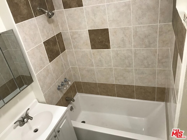 bathroom featuring vanity and tiled shower / bath