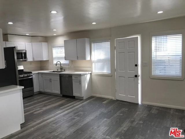 kitchen featuring a healthy amount of sunlight, sink, stainless steel appliances, and white cabinets