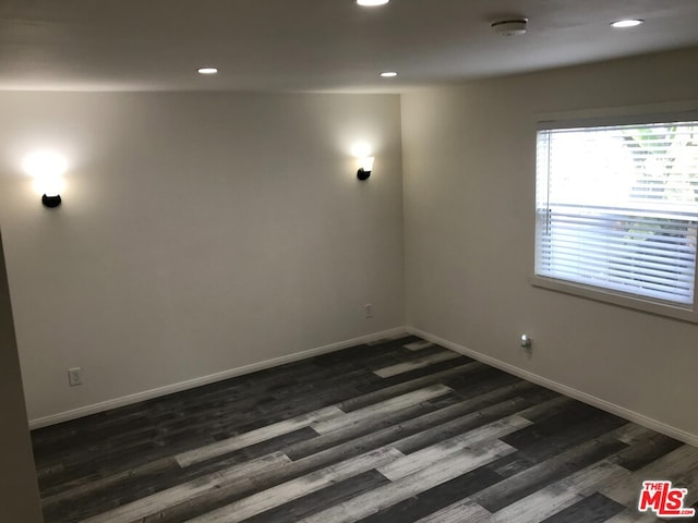 unfurnished room with dark hardwood / wood-style flooring