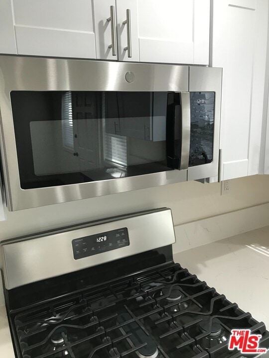 room details with stainless steel appliances and white cabinets