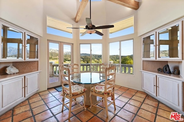 sunroom with ceiling fan, beamed ceiling, and plenty of natural light