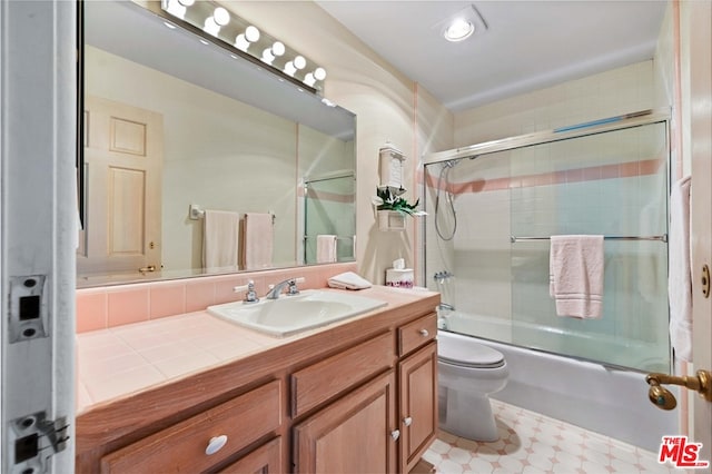 full bathroom with enclosed tub / shower combo, toilet, tile patterned floors, and vanity