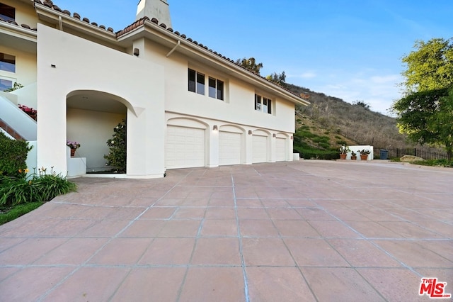 view of side of home featuring a garage and a mountain view